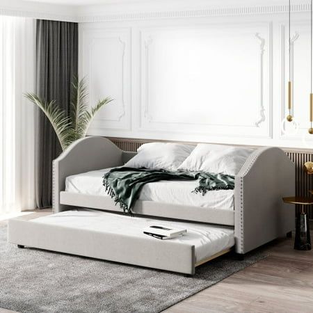 a white day bed sitting on top of a wooden floor