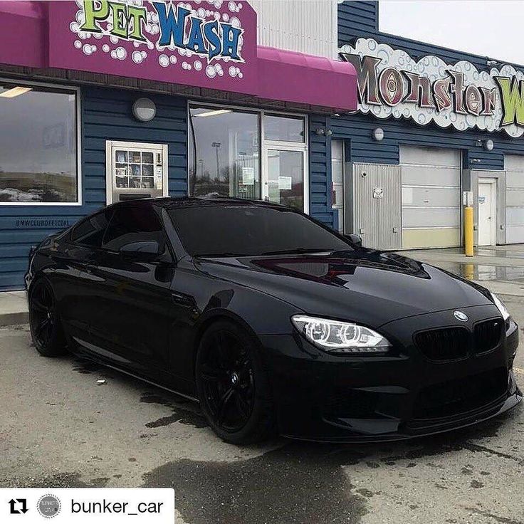 a black car parked in front of a pet wash