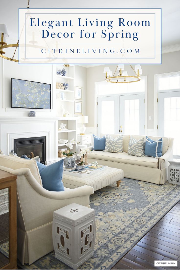 a living room with white furniture and blue accents