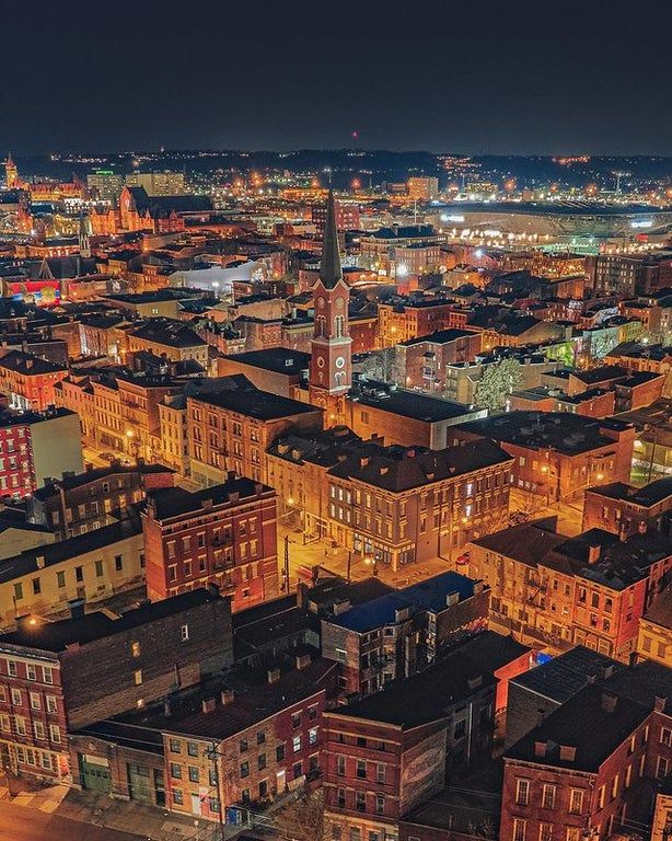 an aerial view of a city at night with lots of tall buildings in the foreground