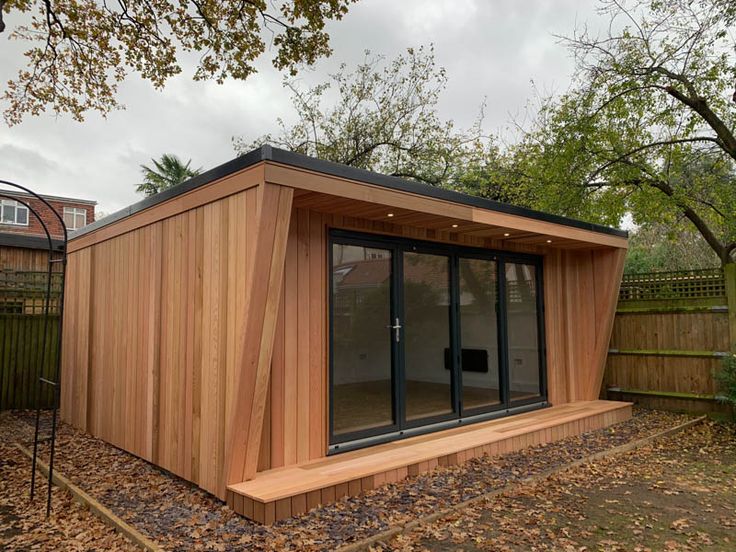 a small wooden building sitting in the middle of a yard