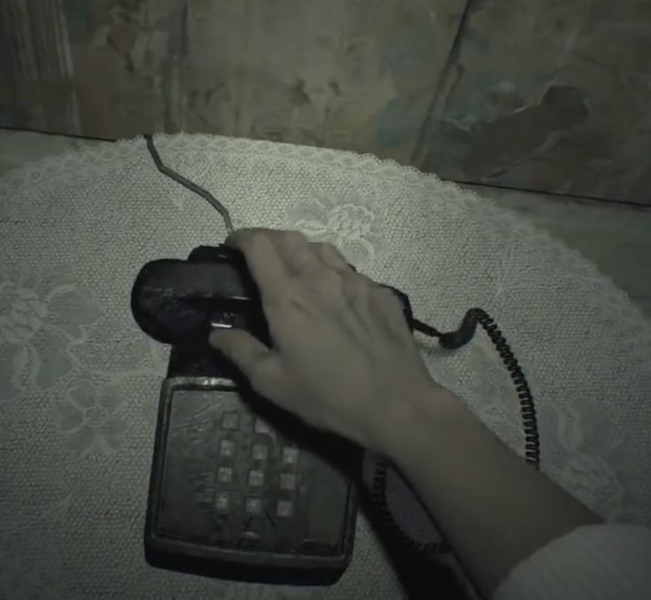 a person is holding an old fashioned phone in their hand and pressing the button on it