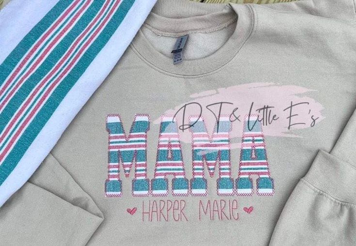 two shirts with the word mama on them next to a pair of striped pants and a tie