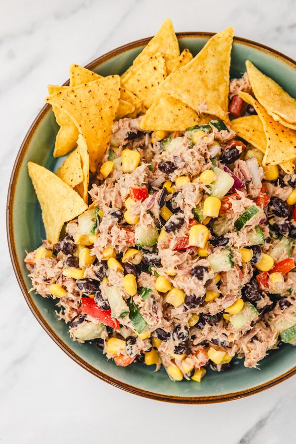 a bowl filled with salsa and tortilla chips on top of a marble counter