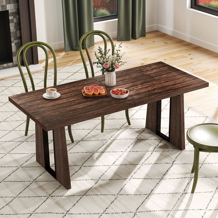 a dining table with two chairs and a bowl of fruit on the table next to it