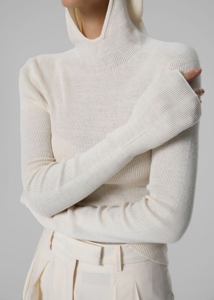 Color: White Lightweight knitted fabric Slim fit High neck Attached hood Long sleeves Slip on style Unlined 60% Acrylic 20% Cotton 20% Polyester Dry Clean By The Frankie Shop. Imported White Fitted Sweater For Layering, White Knitted High Neck Sweater, Winter White High Neck Sweater For Winter, White Ribbed Long Sleeve Turtleneck, High Neck Winter White Sweater, Winter White Turtleneck Top, Winter Ribbed Turtleneck Knit Top, White Soft Knit Winter Sweater, Casual Fitted Knit Turtleneck