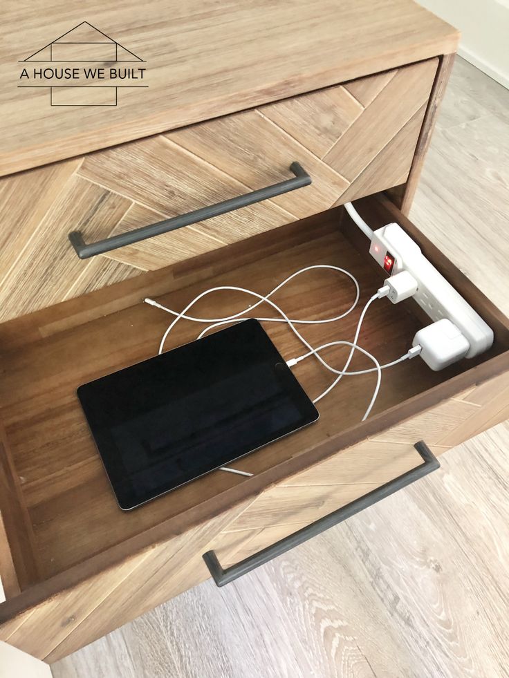 an electronic device is plugged into the charging station in this wooden drawer with drawers