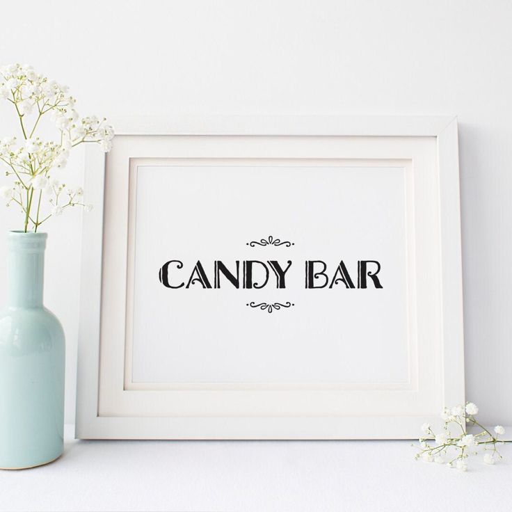 there is a vase with flowers in it next to a candy bar sign