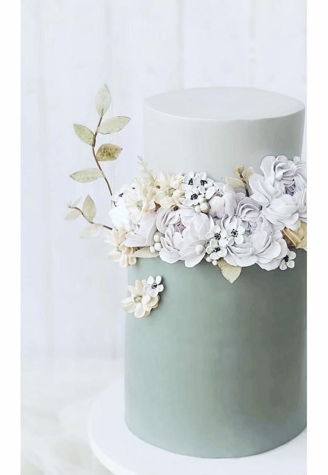 a white and blue cake with flowers on top