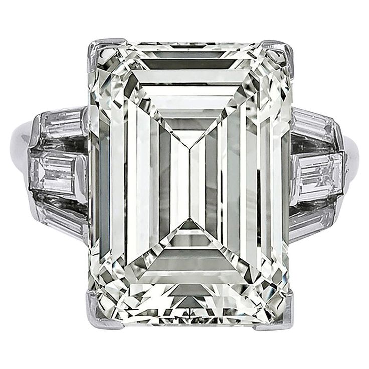 A stunning engagement ring boasting an emerald-cut diamond weighing 11.96 carats. Accompanied by a GIA report stating that the diamond is of O-P color, VS1 clarity. 6 tapered baguette diamonds on the sides. Metal is 18k white gold. Gross weight is 7.06 grams. Size 6.5. Sizable. Ruby Diamond Engagement Ring, Classic Diamond Engagement Ring, Emerald Cut Diamond Engagement Ring, Emerald Cut Diamond Engagement, Contemporary Engagement Rings, Emerald Cut Diamond Ring, Expensive Jewelry Luxury, Emerald Diamond Ring, Modern Engagement Rings