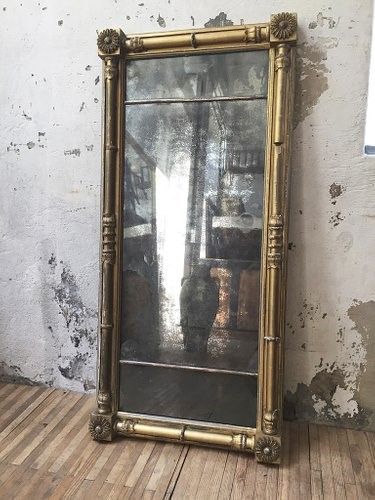 a mirror sitting on top of a wooden floor next to a wall