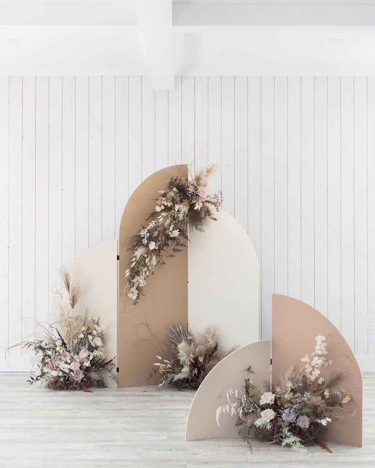 an assortment of flowers are placed on top of cardboard boxes in front of a white wall