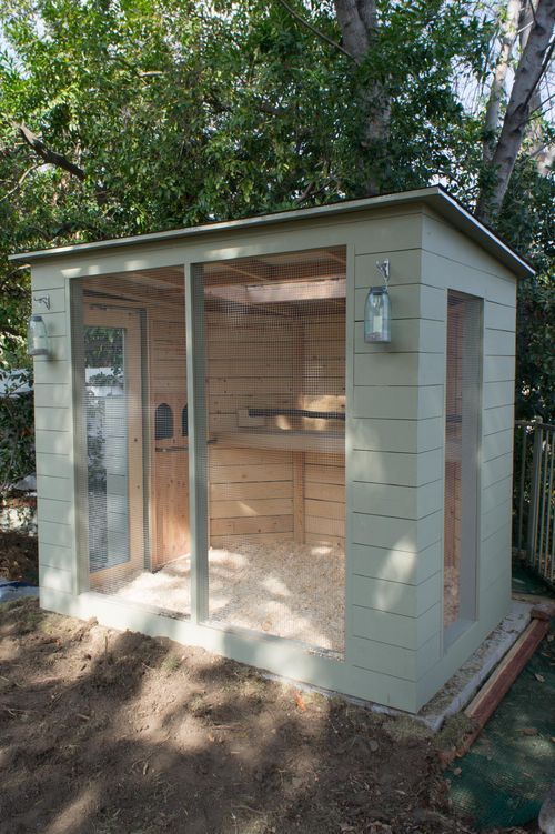 a small outdoor sauna in the middle of a yard with trees and dirt around it