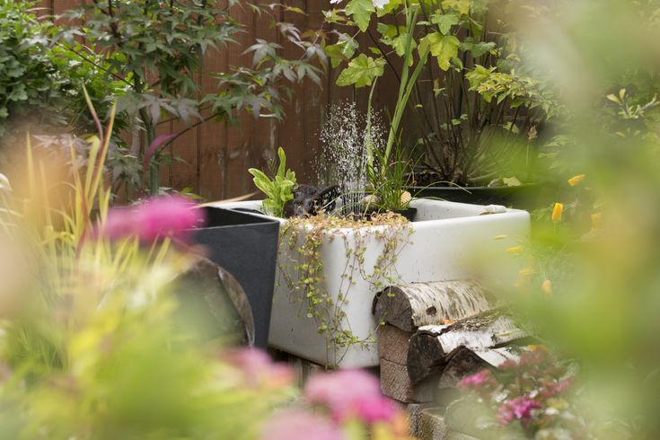 a planter filled with plants next to a wooden fence