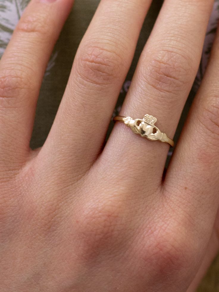 a woman's hand with a gold ring on it