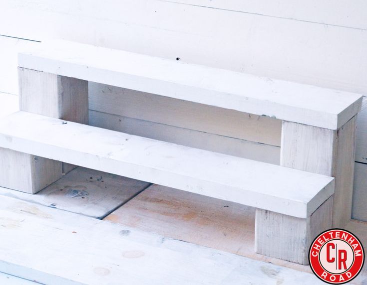 a white bench sitting on top of a wooden floor