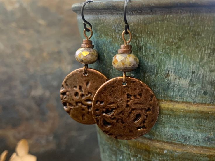 a pair of brown earrings with flowers on them