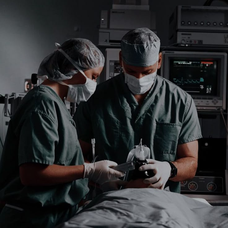 two doctors in scrubs operating on a patient