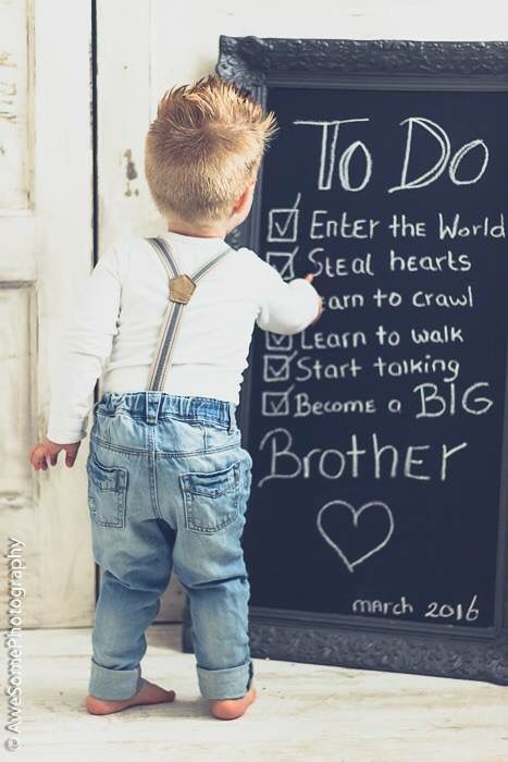 a little boy standing in front of a chalkboard with words written on it that say to do