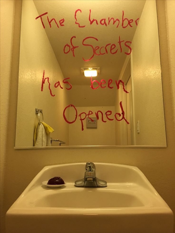 a bathroom mirror with writing on it and a sink in the foreground that reads, the 5 chamberber of secrets has been opened