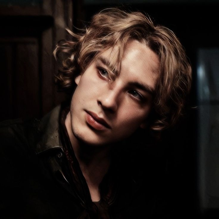 a young man with curly hair and blue eyes