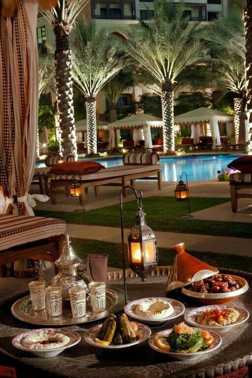 a table filled with food next to a pool