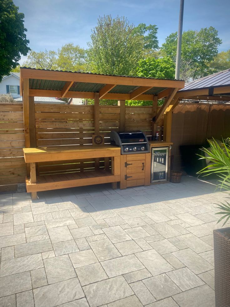 an outdoor kitchen area with grill and sink