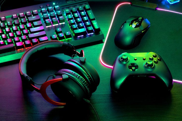 a gaming keyboard, mouse and headphones on a desk with neon lights in the background