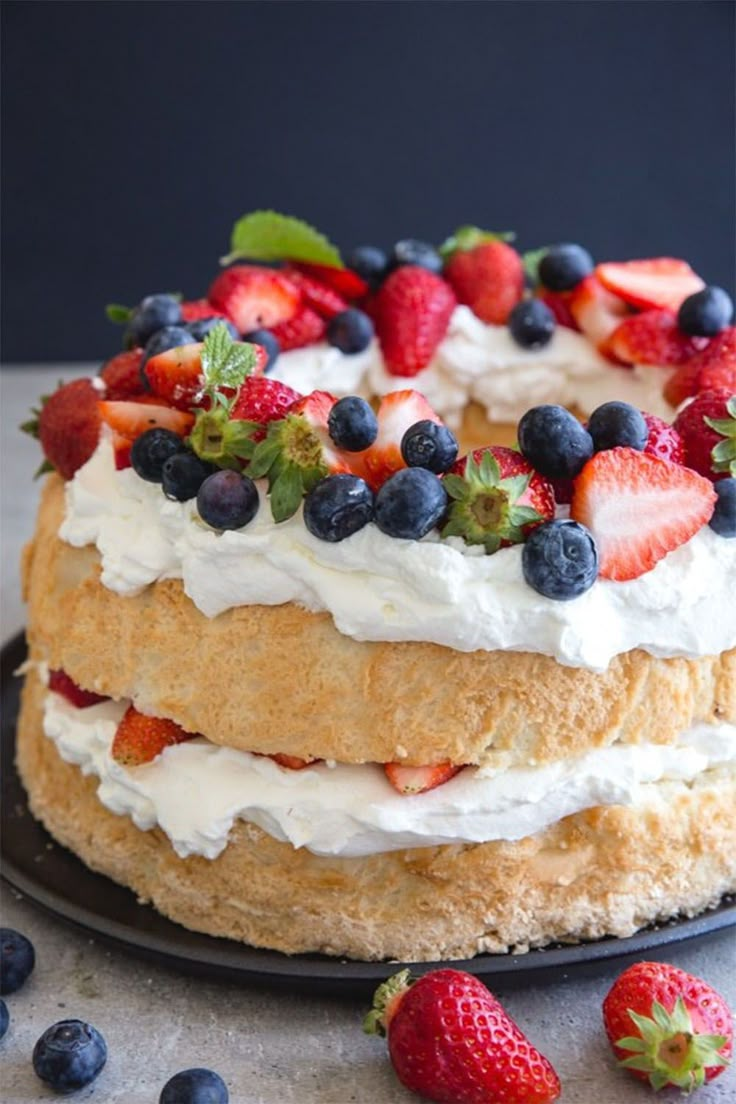 a cake with strawberries and blueberries on top