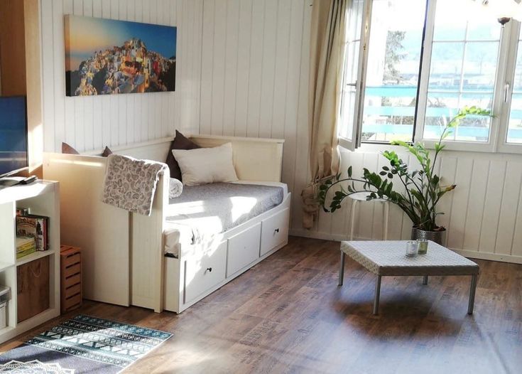 a living room filled with furniture and a flat screen tv sitting on top of a wooden floor