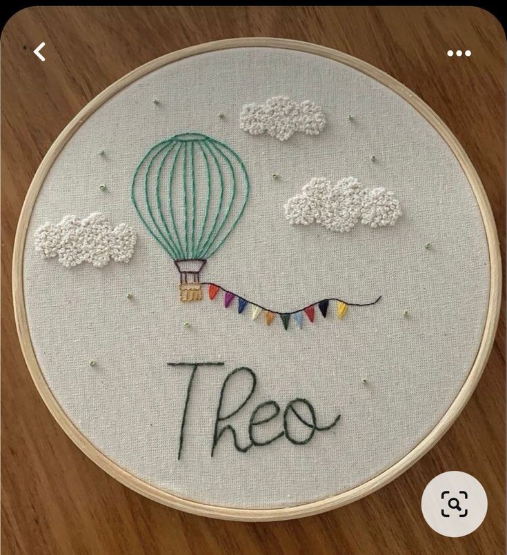 there is a embroidery on the table that says, these are hot air balloons in the sky