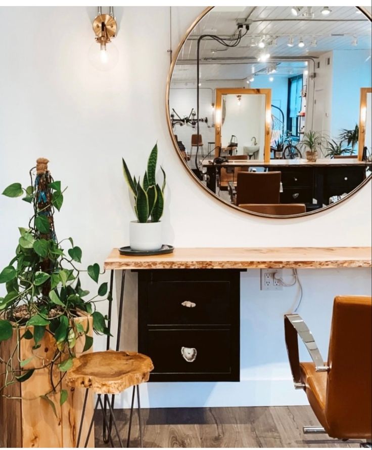 a mirror sitting on top of a wooden table next to a plant in a pot