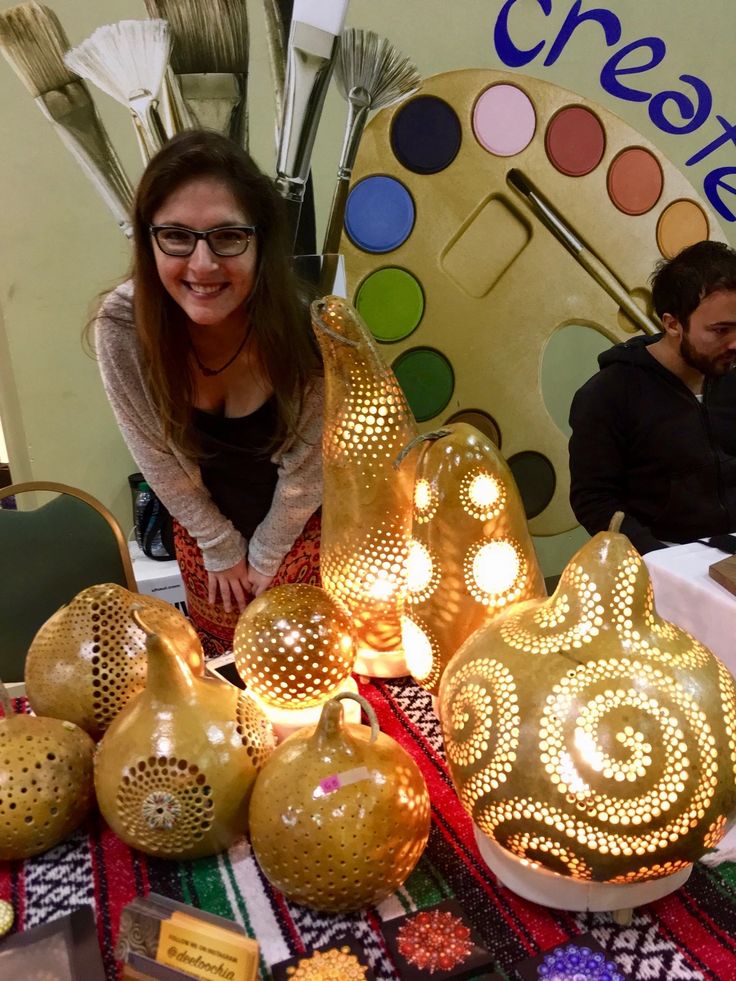 a woman sitting at a table surrounded by decorative items