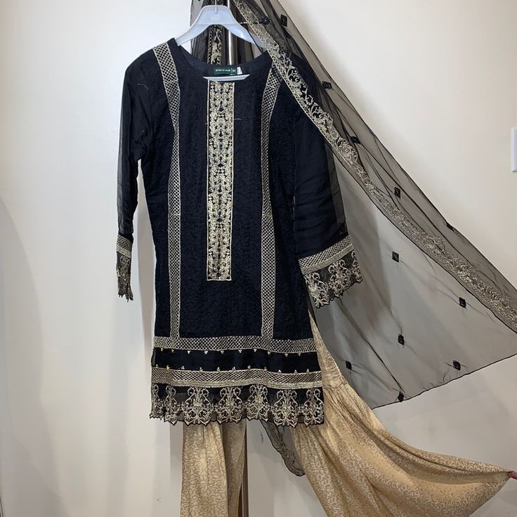 Color: Black With Gold Embroidery Fabric: Organza Suit With Banarssi Sharara Size For Shirt: -Length= 35’’ -Chest = 20’’ -Sleeve = 22’’ Size For Sharara (Pants) -Length= 37’’ -Waist With Elastic = 14’’ *This Dress Is In Very Good Condition, It’s Been Worn Twice. *Feel Free To Make An Offer Embellished Black Sharara For Eid, Semi-stitched Embellished Black Sharara, Embellished Semi-stitched Black Sharara, Designer Black Embellished Sets, Festive Embellished Black Traditional Wear, Elegant Embellished Black Sharara, Elegant Black Embellished Sharara, Semi-stitched Embellished Black Salwar Kameez, Bollywood Style Embellished Black Salwar Kameez