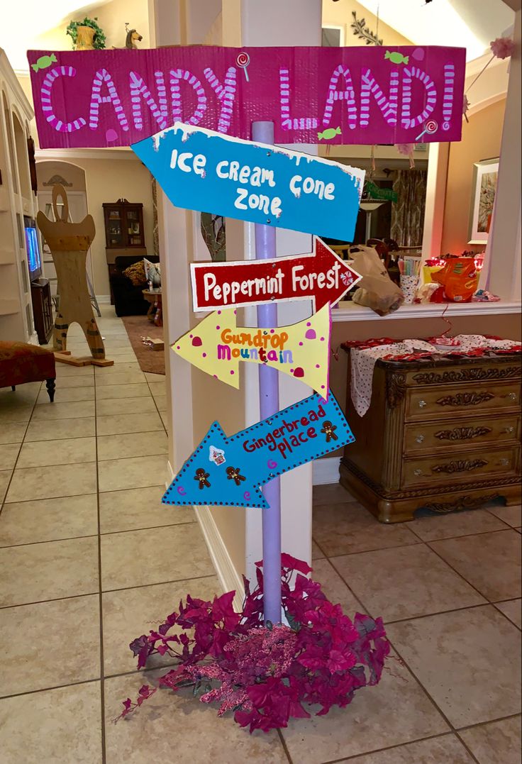 a candy land sign in the middle of a room with pink and blue decorations on it