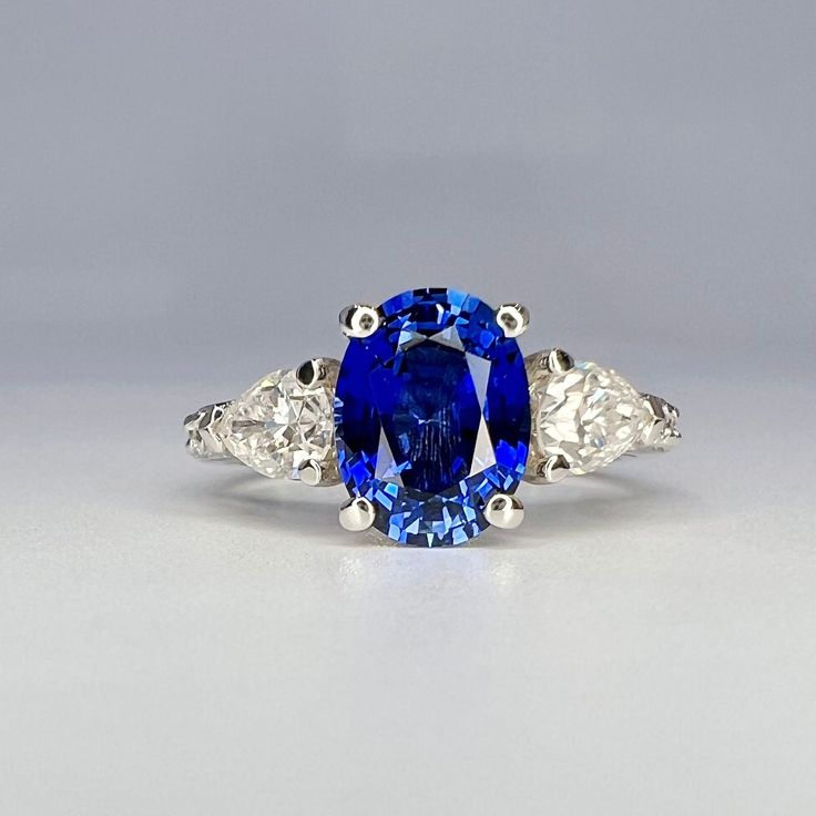 a blue and white diamond ring with three diamonds