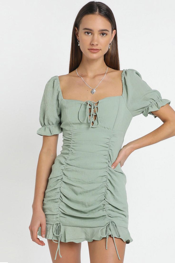 Description: For a relaxed date or gathering in the spring summer season, this sage green ruched bodycon mini dress in our boutique is a nice choice. Drawstring design and ruffle styling make this outfit sweet and romantic. Featuring a bustier-style bodice with a lace-up at front, short puff sleeves with elasticated cuffs, a hidden zip closure at back, a body-con silhouette with ruching drawstrings at front, and a short dress cut with flouncy hem, this flirty mini dress for women feels so fresh right now. Style it with anything from sneakers to slides, stilettos to ankle boots for an effortless chic outfit. Effortless Chic Outfits, Knit Dress Pattern, Ruffle Bodycon, Zebra Dress, Ruffles Fashion, Half Sleeve Dresses, Mini Dresses For Women, Long Sleeve Short Dress, Puff Sleeve Dresses