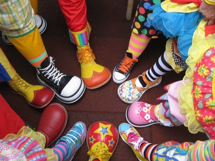 several people wearing brightly colored shoes standing in a circle