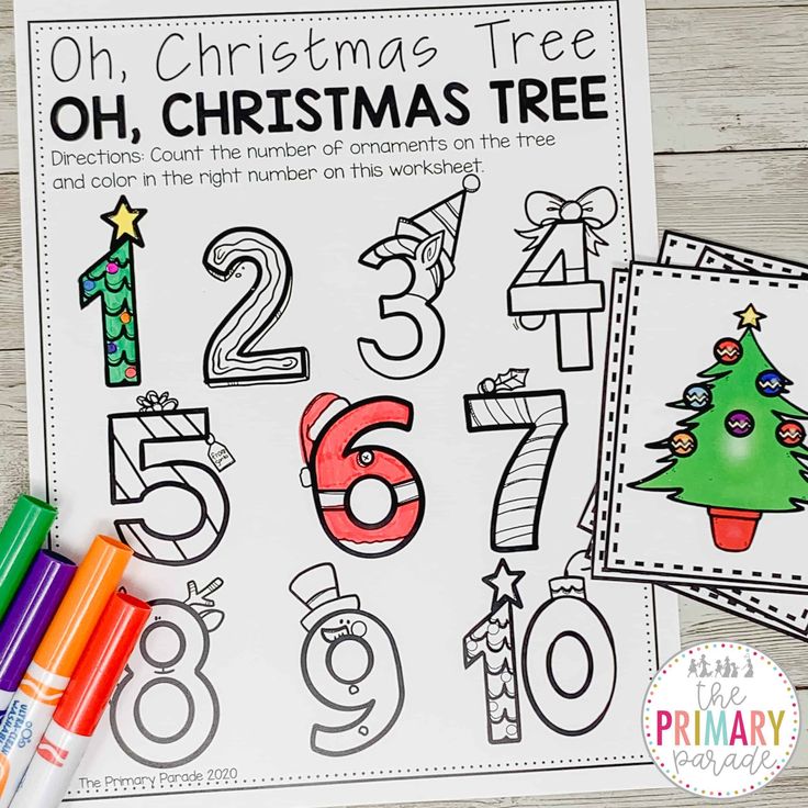 a christmas tree and numbers coloring page with markers on the table next to it,