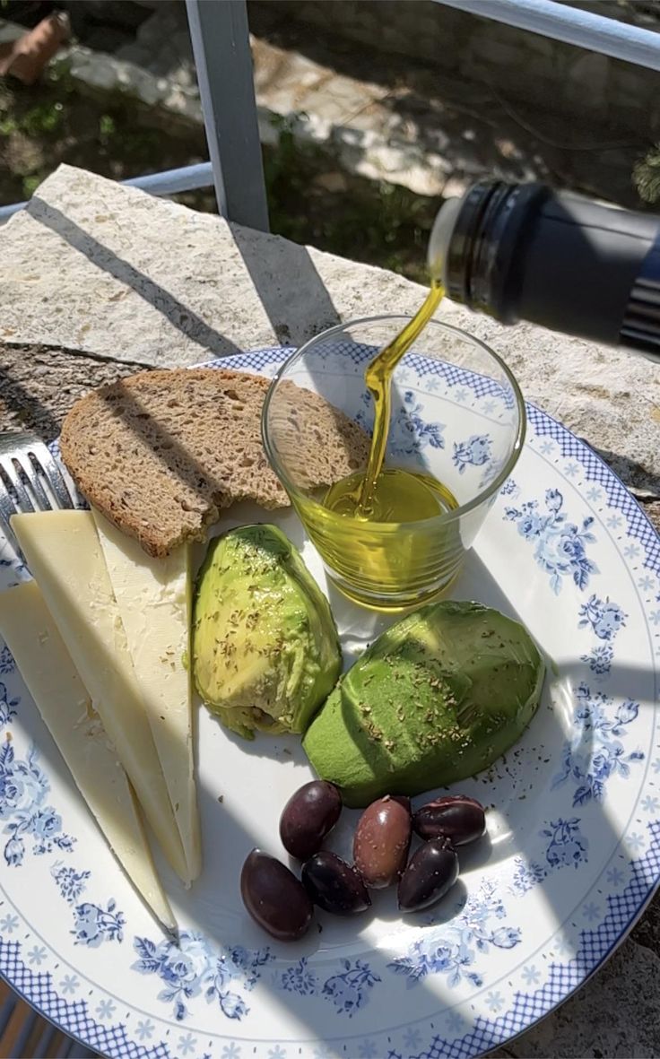 a plate with bread, cheese and olives on it