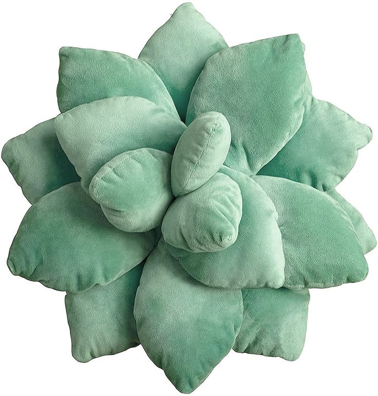 a green flower shaped pillow sitting on top of a white surface