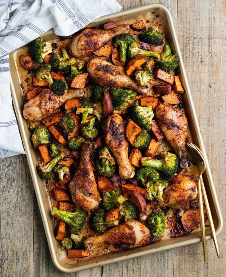 chicken, broccoli and carrots in a casserole dish on a wooden table