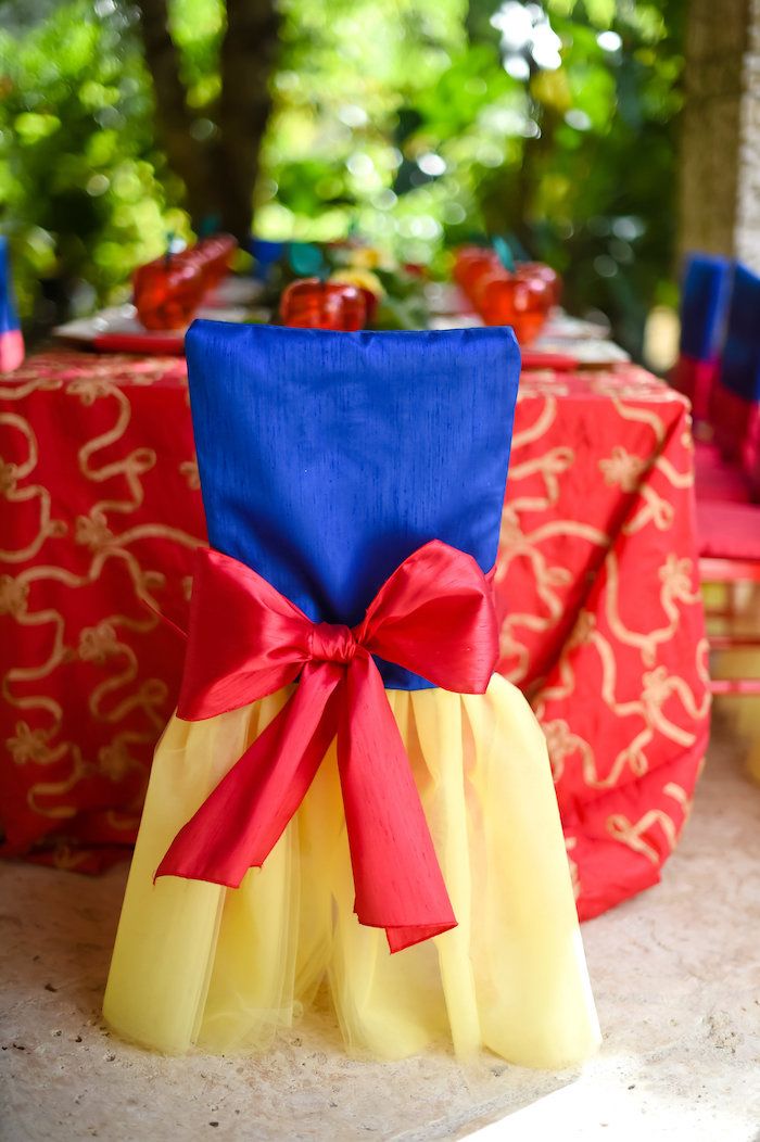 there is a red and yellow chair with a bow on it's seat cover