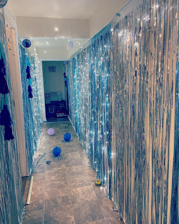 the hallway is decorated with blue balloons and streamers on the glass curtained walls