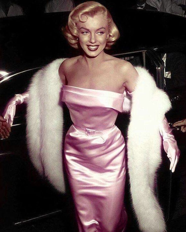 a woman in a pink dress and fur coat