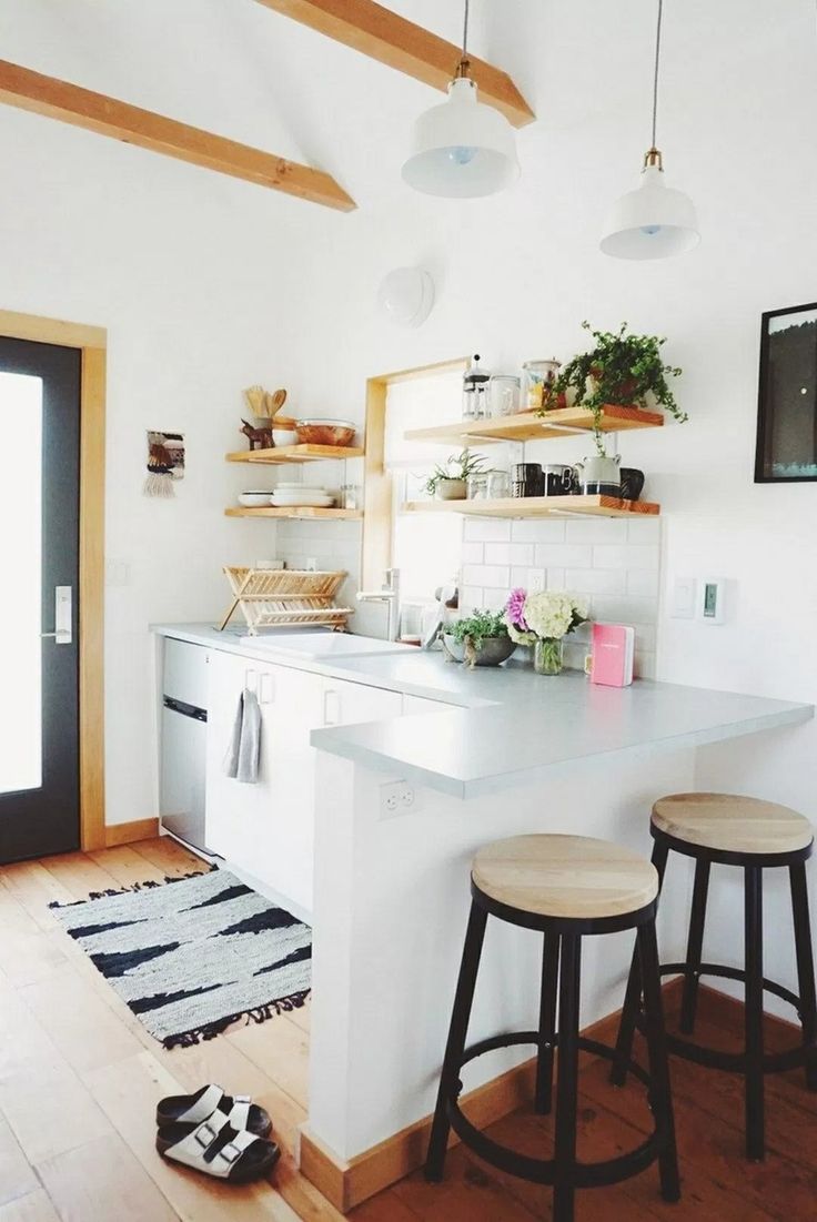 a kitchen with two stools next to a counter top and shelves on the wall