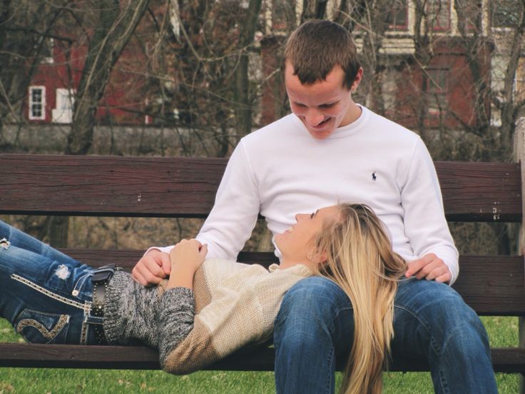 a man and woman sitting on a park bench