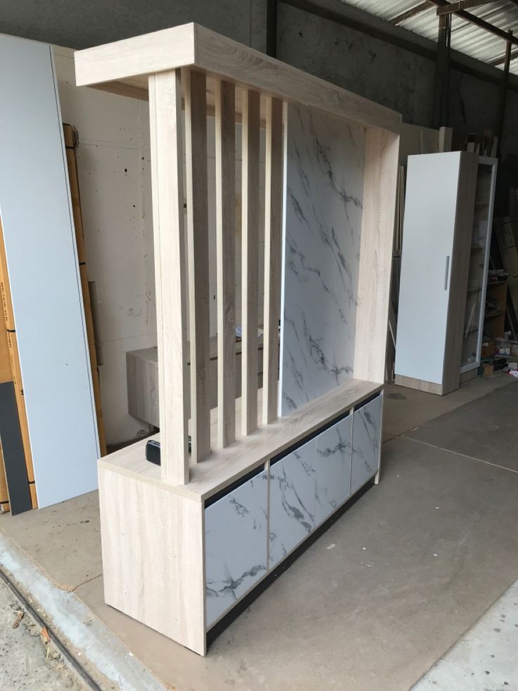 an unfinished cabinet with marble on it in a garage area next to other cabinets and tools