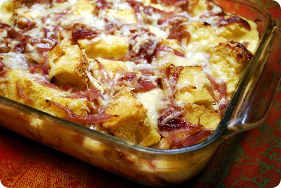 a casserole dish with meat and cheese in it sitting on a colorful table cloth