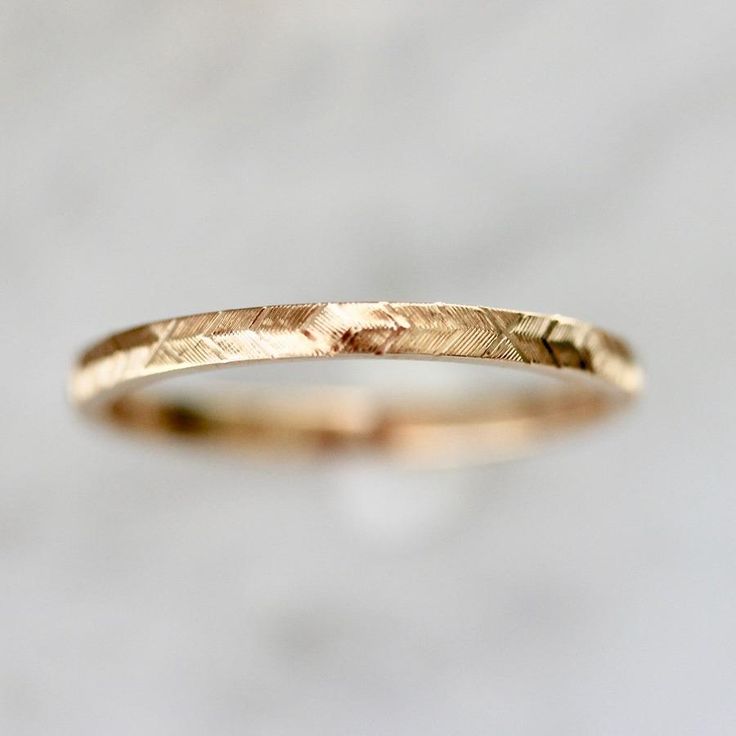 Why I Love It: A modern take on a classic gold band design. Swift and careful hand movements create this wheat engraved texture with precise detail and extraordinary design in your choice of golds. The Details: 14k Yellow Gold, 14k White Gold, 14k Rose Gold, 18k Peach Gold® Band Width is Approx. 1.80 mm Band Height is Approx. 1.30 mm Made to order in your size, please allow approximately 4 to 6 weeks for delivery Bands are all hand engraved and may come with subtle variations left by the artist 1.5mm Wedding Band, Carved Wedding Bands For Women, Delicate Gold Engraved Ring For Wedding, Delicate Yellow Gold Engraved Wedding Ring, Engraved Yellow Gold Band Ring, Simple Gold Wedding Band Engraved, Yellow Gold Brass Engraved Wedding Ring, Midi Rings Gold, Handmade Gold Ring